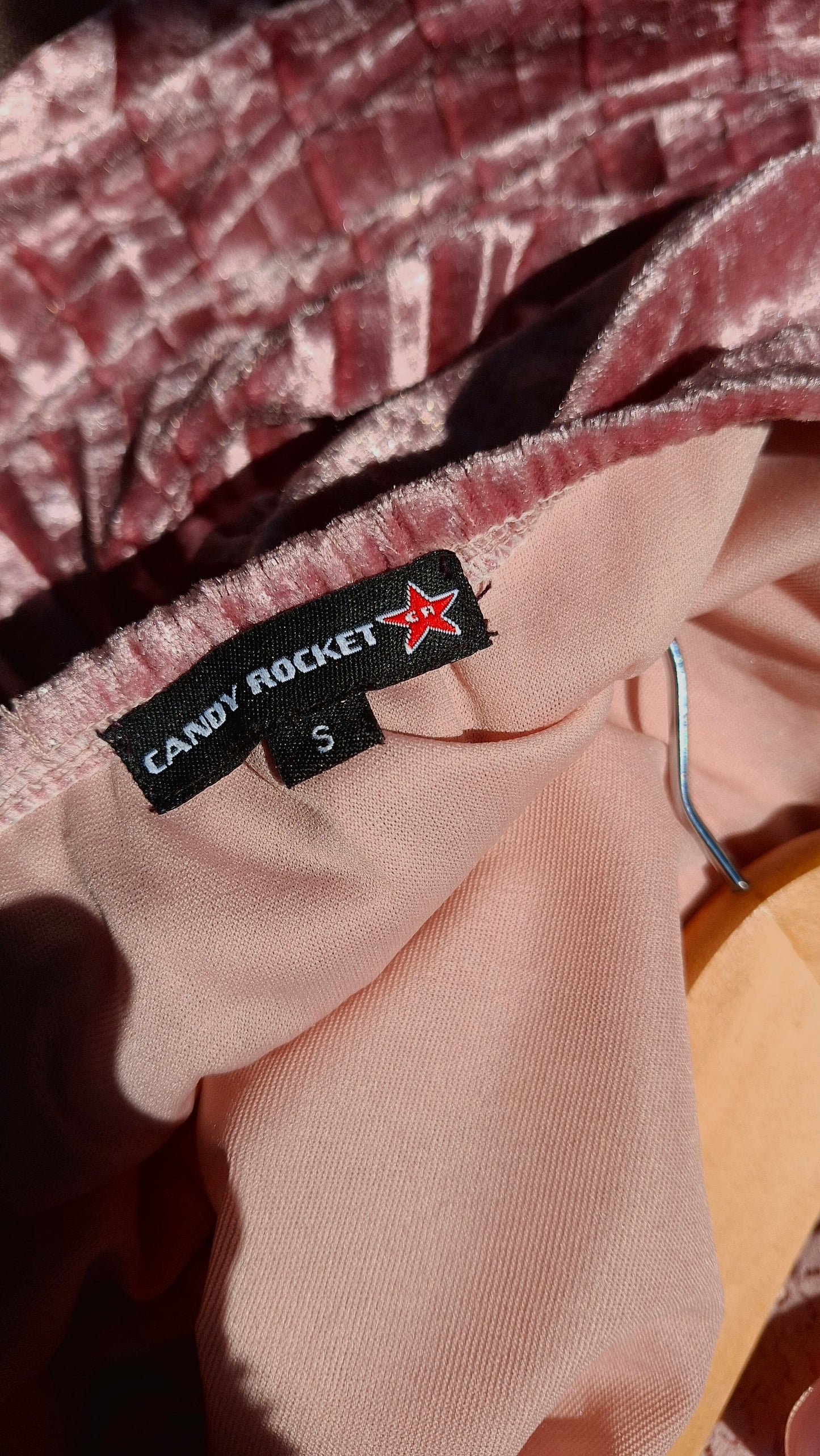 Close-up of a clothing tag on a garment with a brand logo.