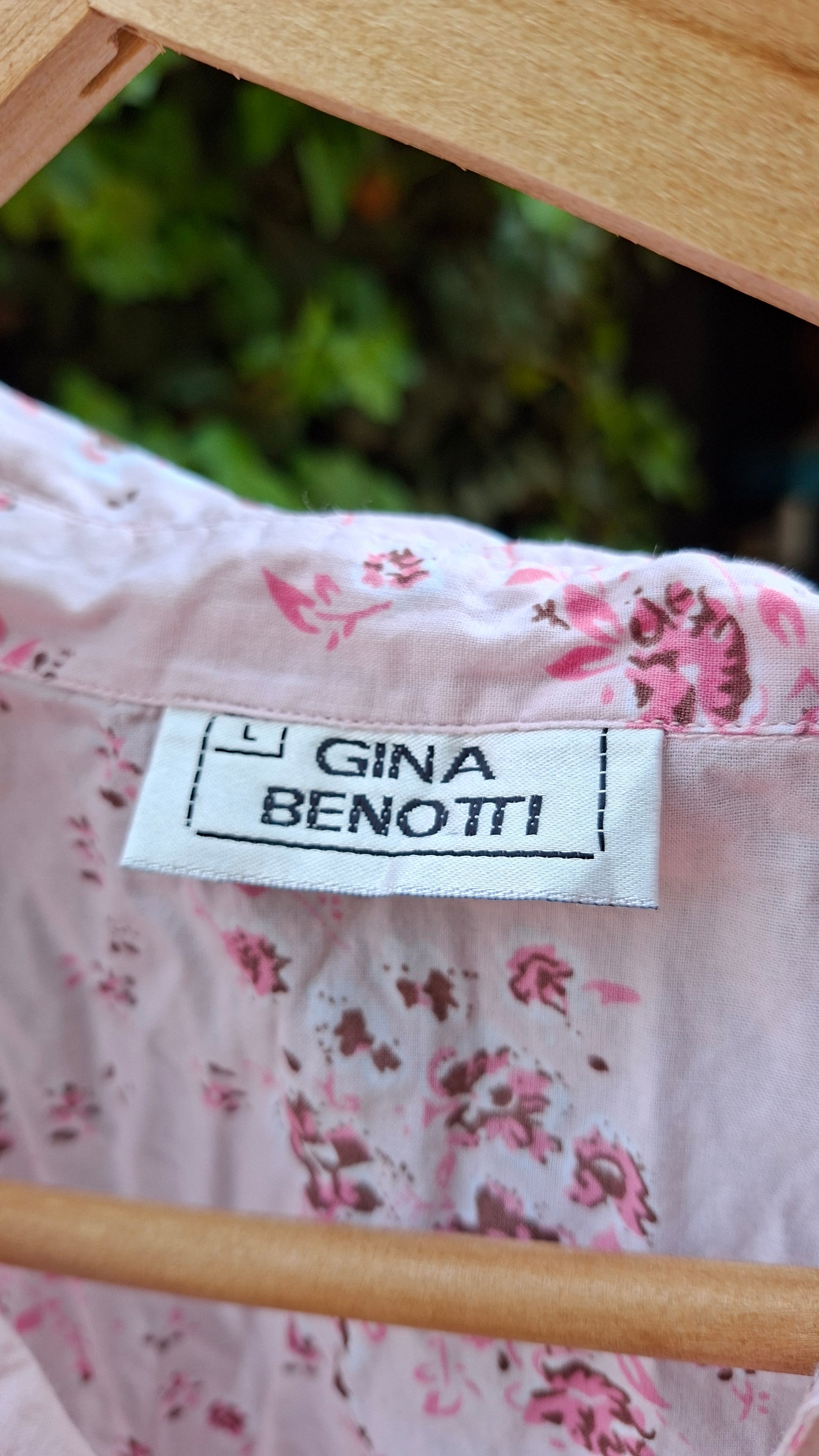 Floral fabric with a Gina Benotti label against a blurred natural background